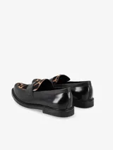 Mocasín negro con detalle animal print en la capellada. Parte superior de cuero, forro de cuero y suela de goma.