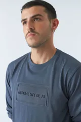 Remera de hombre de manga larga color azul con logo bordado en relieve en el pecho.