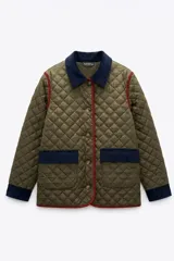 Campera capitoneada color verde oliva con diseño acolchado. Presenta cuello, puños y detalles en los bolsillos de pana azul marino, con ribetes en color bordó. Cuenta con cierre frontal mediante botones.