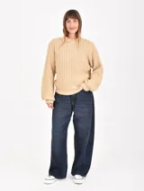 Buzo de tejido de punto grueso en color verde, con cuello redondo, mangas largas y corte holgado.