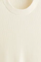 Buzo de algodón fino color crema, con cuello redondo y manga larga. Presenta un tejido de punto acanalado vertical y un bajo recto.