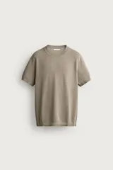 Remera de punto de algodón color gris topo, con cuello redondo, manga corta y acabado en rib elástico en cuello, puños y dobladillo. Corte relajado.