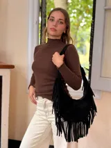 Cartera tipo hobo de cuero negro con diseño de flecos largos en los laterales. Cuenta con una correa de hombro integrada y cierre superior.