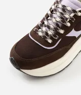 Championes estilo runner de la marca Satinato, confeccionadas en una combinación de poliuretano y mesh respirable. Presentan un diseño con recortes superpuestos en tonos marrón y detalles en lila, cierre con cordones bicolor, lengüeta acolchada, tirador trasero y una suela robusta con entresuela alta y base tractorada.