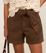 Short de cintura media color crudo, con cinturón de lazo y bolsillos laterales.