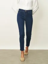 Jean de corte skinny en color azul medio, con tiro medio, cierre frontal con botón y bolsillos laterales y traseros.