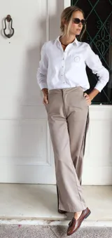 Pantalón de corte sastrero con pierna recta, confeccionado en gabardina y tencel. Presenta un diseño en color beige con detalle de rayas laterales en contraste.