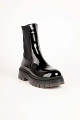 Bota baja de mujer estilo paddock, color negro, con suela track gruesa y caña de tejido elástico.