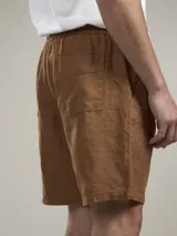 Bermuda de lino color camel, con bolsillos laterales y cintura elástica.