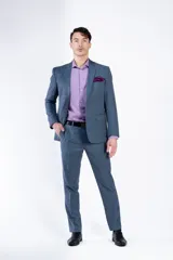 Ambo de corte slim fit compuesto por saco de dos botones con solapa clásica y pantalón de vestir a juego, en color azul con textura sutil.