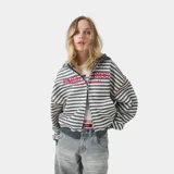 Hoodie de algodón con cierre frontal completo, diseño a rayas horizontales blancas y grises, capucha azul marino, y bordado "EMESTUDIOS Always Grateful" en el pecho en color rojo. Cuenta con bolsillos delanteros tipo canguro, puños y bajo de canalé, y un pequeño logo bordado en la parte posterior de la capucha.