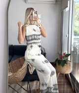 Conjunto de top sin mangas y pantalón palazzo con cintura elastizada, ambos de color crudo con estampado de flores y motivos geométricos en negro.