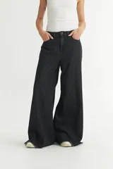 Pantalón jean negro de pierna ancha, corte holgado y tiro medio.
