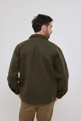 Sobrecamisa de tejido grueso sin forro, con diseño de corte holgado y silueta cuadrada. Presenta cuello clásico, cierre frontal con botones mate y dos bolsillos en el pecho con solapa.