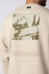 Buzo de cuello redondo y corte oversize, confeccionado en frisa suave. Presenta un diseño minimalista en color negro con un pequeño logo ovalado en el centro del pecho y una estampa sutil en el lateral inferior derecho.