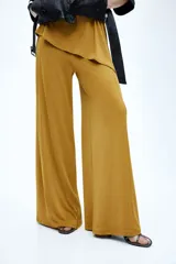 Pantalón holgado confeccionado en punto suave, de color mostaza, con cintura elástica oculta y piernas amplias de corte recto.