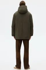 Campera parka acolchada repelente al agua y rompevientos, con cuello alto, capucha ajustable, cierre frontal con solapa y bolsillos frontales tipo parche y calientamanos.
