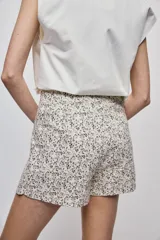 Short cruzado de tiro medio confeccionado en algodón, con diseño que imita una falda en el delantero. Presenta cierre lateral invisible y estampado floral sutil.