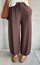 Pantalón de corte babucha color chocolate, de diseño holgado con cintura elástica fruncida y cordón ajustable.