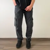 Pantalón cargo de jean azul, de corte recto y tiro medio, con bolsillos laterales con solapa en las piernas.
