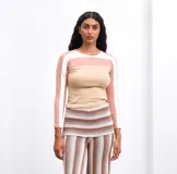 Top de manga larga confeccionado en algodón, con diseño de bloques de color en tonos beige, rosa y blanco, y cuello redondo.