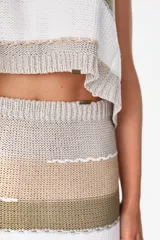 Falda corta de punto con diseño de rayas horizontales en tonos negro, tostado, gris y blanco.