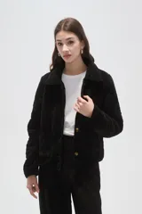 Chaqueta de poliéster con diseño capitoneado, cuello tipo camisa, cierre frontal con botones y bolsillos delanteros.