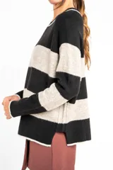 Sweater de punto con rayas horizontales en tonos azul, marrón y beige, de corte holgado y manga larga.