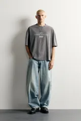 Remera de corte relaxed fit con efecto lavado, cuello redondo y manga corta, con estampado frontal contrastante.