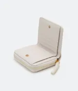 Billetera pequeña color blanco con textura geométrica de triángulos. Tiene cierre perimetral con cremallera, monedero interno con cierre, múltiples ranuras para tarjetas y logo metálico dorado en la esquina inferior.