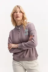 Buzo de algodón color lila, de calce relajado y hombros caídos, con estampa pequeña en el frente que dice "Palm Beach" y una palmera.