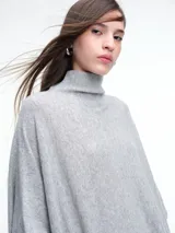 Poncho amplio de cuello alto, confeccionado en hilado con lana y cashmere, con diseño de caída recta y botones laterales.