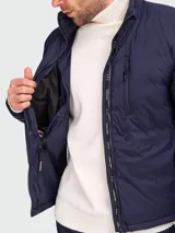 Campera acolchada azul marino marca Canada Goose, modelo Lodge, con cierre frontal, cuello alto y logo en el brazo.