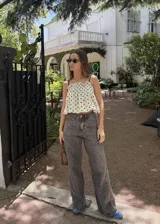 Pantalón jean azul oscuro, de corte wide leg y tiro medio. Presenta detalles de costuras diagonales en la parte superior.