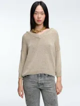 Sweater de punto con brillo, de calce relajado, escote en V y hombros caídos. Presenta mangas largas con puños acanalados y un diseño de peso medio con caída suave.