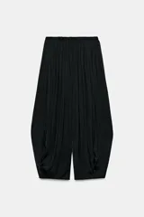 Pantalón bombacho negro confeccionado en tejido satinado, de tiro medio con cintura elástica y diseño con pliegues.