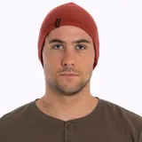 Gorro tipo beanie de tejido de punto en color rojo ocre, con diseño de doble capa y etiqueta de la marca Merrell en el lateral.
