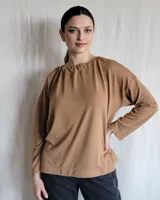 Remera de manga larga confeccionada en lanilla, con diseño holgado y escote redondo fruncido.