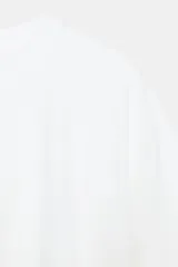 Camiseta cropped blanca de algodón 100%, con cuello redondo, manga corta y bajo abullonado con pliegues.