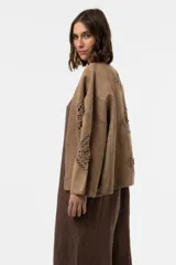 Chaqueta de gamuza color beige, con calce amplio y relajado, mangas anchas y detalles de inserciones de crochet con motivos florales.