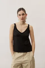 Musculosa de lino color negro con tirantes anchos de encaje y detalle de aplique metálico con la marca en la parte posterior.