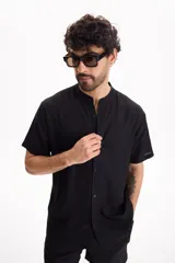 Camisa de lino de manga corta, color blanco, con cuello mao y cierre frontal de botones.