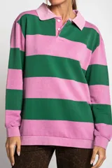 Sweater tipo polo de manga larga con diseño de rayas horizontales anchas en color rosa y gris. Presenta cuello camisero con cierre frontal de botones y puños elásticos.