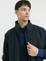 Campera de micropolar color verde oscuro, con cuello alto, cierre frontal completo, bolsillos laterales y un bolsillo con cierre en el pecho.