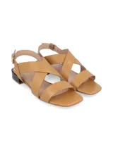 Sandalias de cuero color camel con diseño de tiras cruzadas en el empeine, cierre con hebilla lateral y taco bajo cuadrado en color negro.