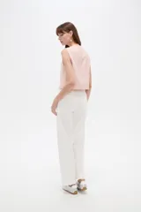 Musculosa cropped de viscosa color rosado, con cuello a la base, pequeña abertura frontal y detalle de hebilla metálica decorativa.