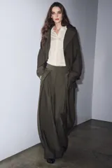 Pantalón de tiro medio color beige perteneciente a la colección ZW Collection, de corte ancho y recto, con detalle de pliegues frontales y cierre con cremallera y ganchos metálicos.