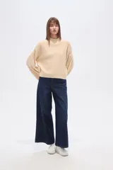 Polera de punto color marrón con destellos brillantes, cuello redondo, mangas largas abullonadas y diseño holgado.