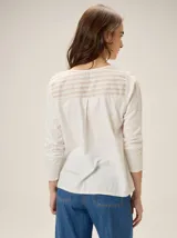 Remera de algodón con diseño combinado que presenta un panel central a rayas verticales en tonos crudo y beige, y mangas lisas en color crudo. Incluye un pequeño bordado con el número 1986 en la parte superior del pecho.
