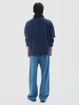 Buzo de felpa azul marino con interior de friza, cuello alto negro y media cartera con cierre. Presenta un corte horizontal en el pecho en color beige con el logo "PASTICHE" bordado en negro.